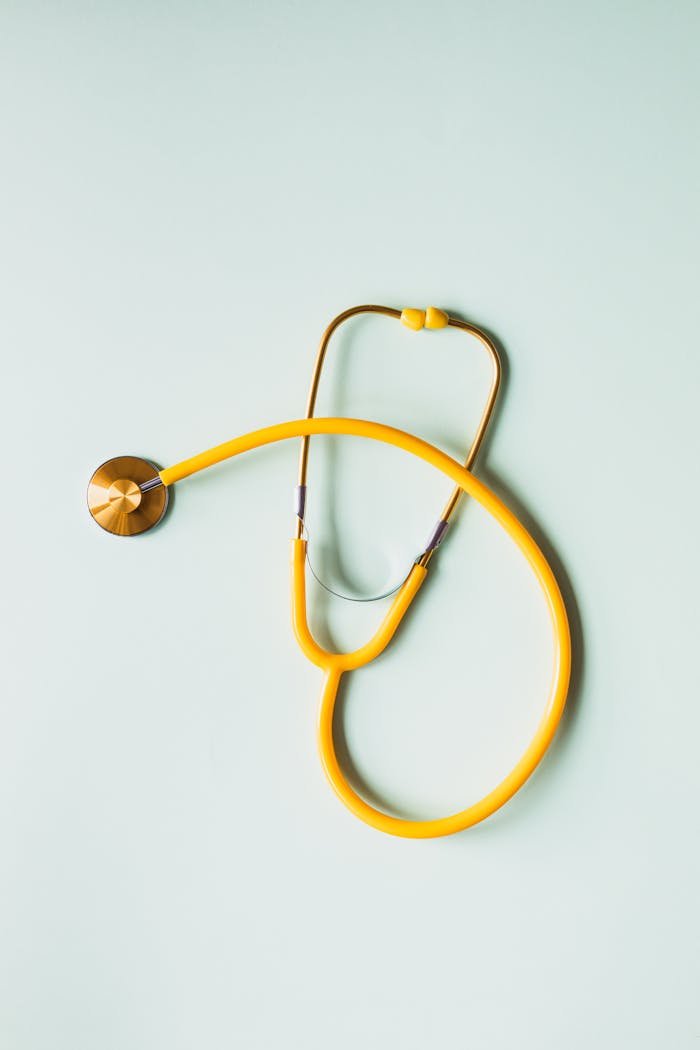 Top view of yellow medical stethoscope placed on white surface during coronavirus pandemic